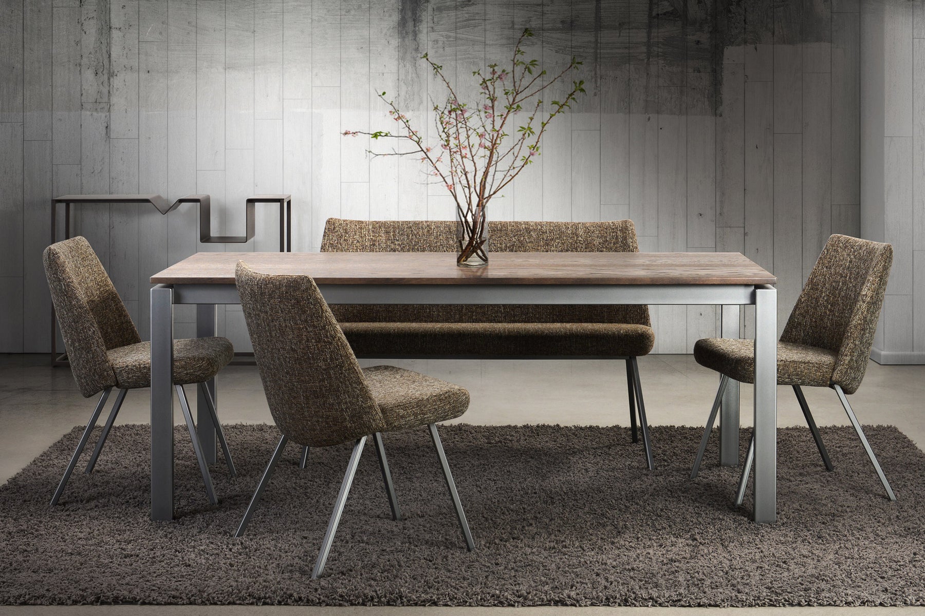 A simple modern dining table with a slim metal base and a glass or wood ...